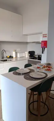 a kitchen with a counter with chairs and a table at Casa Isa - Funchal in Funchal