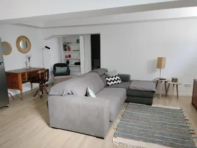 a living room with a gray couch and a piano at MerakiHouse in Funchal