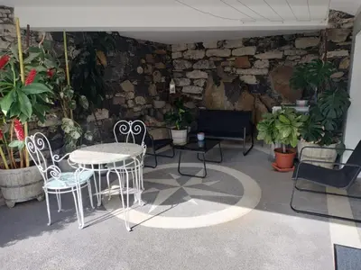 a patio with a table and chairs and plants at MerakiHouse in Funchal