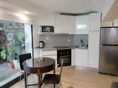 a kitchen with a table and a refrigerator at MerakiHouse in Funchal