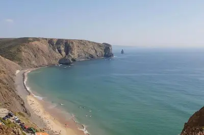a view of a beach with a lighthouse in the ocean at Wanderlust - Beautiful Villa in Aljezur in Aljezur