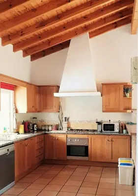 a kitchen with wooden cabinets and a stove top oven at Wanderlust - Beautiful Villa in Aljezur in Aljezur