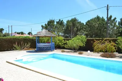 a swimming pool with a chair and a gazebo at Wanderlust - Beautiful Villa in Aljezur in Aljezur