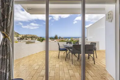 a patio with a table and chairs on a balcony at CoolHousesAlgarve Luz, 3 bed linked house, pool, superb panoramic sea view, Casa das Buganvílias in Luz