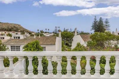 a white fence with houses in the background at CoolHousesAlgarve Luz, 3 bed linked house, pool, superb panoramic sea view, Casa das Buganvílias in Luz