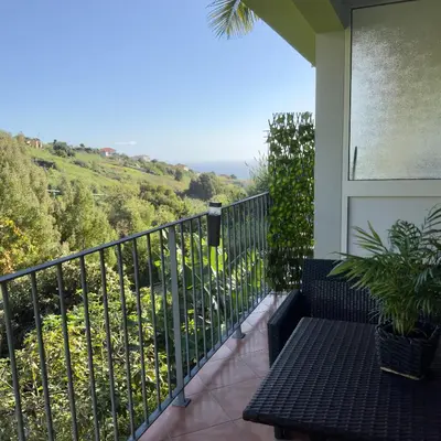 a balcony with a bench and a view at Green House in Calheta
