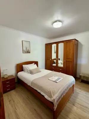 a bedroom with a large bed and a wooden cabinet at Green House in Calheta