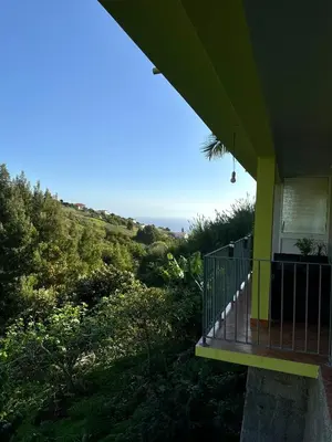 a balcony of a house with the ocean in the background at Green House in Calheta