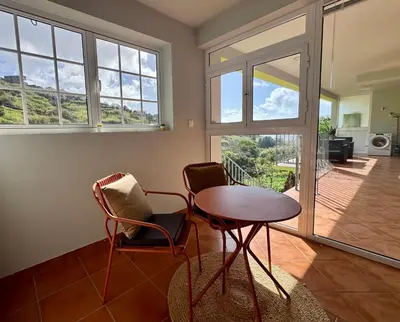 a living room with a table and two chairs at Green House in Calheta