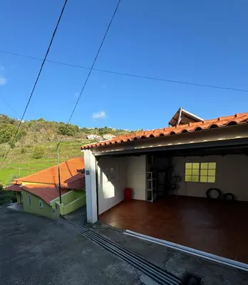 a house with a large deck in front of it at Green House in Calheta