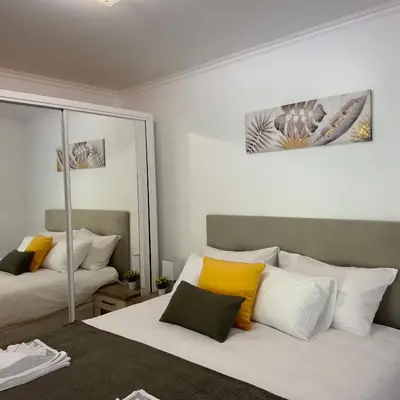 a bedroom with two beds with yellow and white pillows at Green House in Calheta