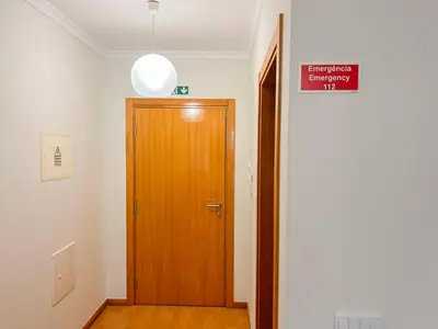 a hallway with a wooden door and a sign at Sandie's Serene Stay in Caniço