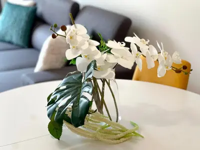 a vase filled with white flowers on a table at Sandie's Serene Stay in Caniço