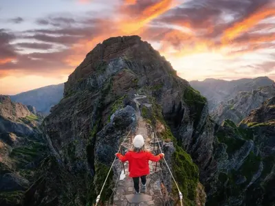 a person walking on a suspension bridge on a mountain at Sandie's Serene Stay in Caniço