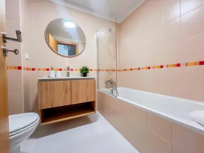 a bathroom with a tub and a toilet and a sink at Sandie's Serene Stay in Caniço