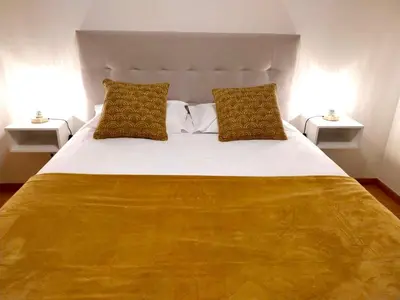 a bedroom with a large bed with two side tables at Sandie's Serene Stay in Caniço
