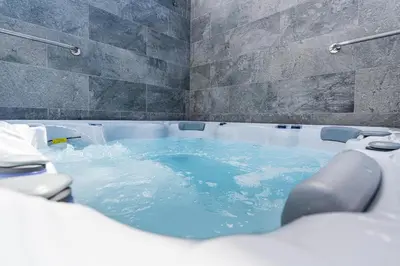 a bath tub filled with blue water in a bathroom at Star House -Jacuzzi & Aircon in Calheta