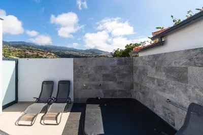 two chairs sitting on a balcony with a view at Star House -Jacuzzi & Aircon in Calheta