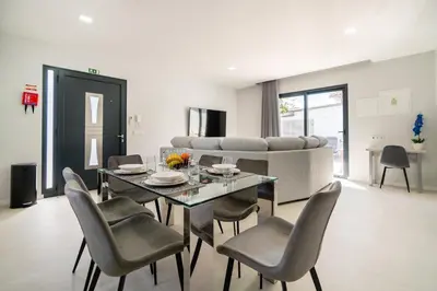 a dining room with a table and chairs and a couch at Star House -Jacuzzi & Aircon in Calheta