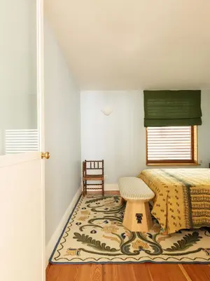 a bedroom with a bed and a table and a rug at Carmo 33 in Funchal