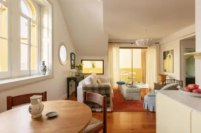 a kitchen and living room with a table and chairs at Carmo 33 in Funchal