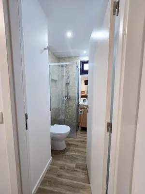 a bathroom with a toilet and a glass shower at S A L - Beach Apartments Caniçal in Machico