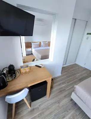 a room with a desk with a mirror and a bed at S A L - Beach Apartments Caniçal in Machico