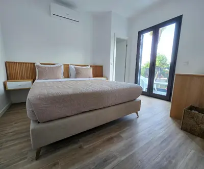 a bedroom with a large bed and a large window at S A L - Beach Apartments Caniçal in Machico