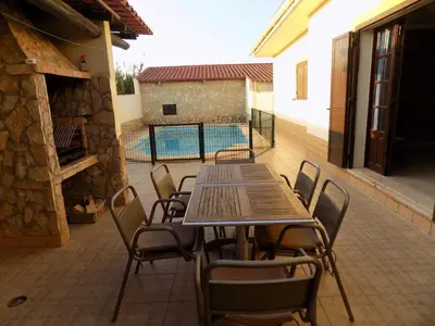 a table and chairs on a patio with a pool at Casa do Cercado, Sagres in Sagres