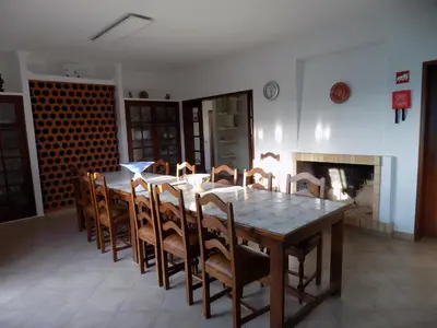 a dining room with a table and chairs and a fireplace at Casa do Cercado, Sagres in Sagres