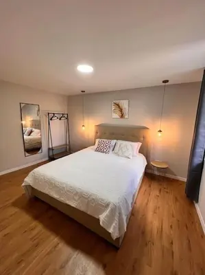 a bedroom with a white bed and wooden floors at Roots Guesthouse - A in São Vicente