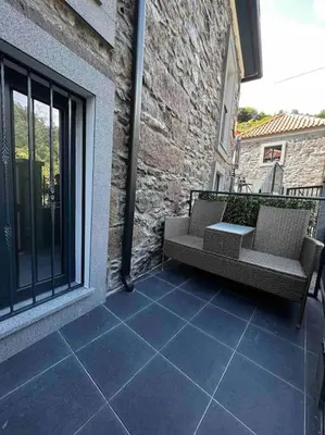a patio with two chairs and a table on a building at Roots Guesthouse - A in São Vicente