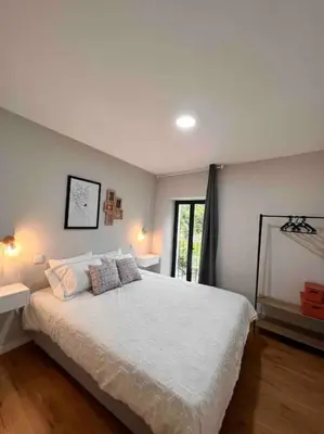 a bedroom with a large white bed and a window at Roots Guesthouse- B in São Vicente