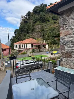 a balcony with a view of a house and a car at Roots Guesthouse- B in São Vicente