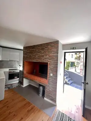 a kitchen with a brick fireplace in a room at Roots Guesthouse- B in São Vicente