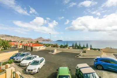 a group of cars parked in a parking lot near the ocean at Hadassa Sunrise Refuge in Porto Santo