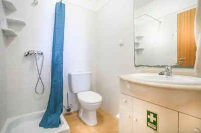 a bathroom with a toilet and a sink and a mirror at Hadassa Sunrise Refuge in Porto Santo