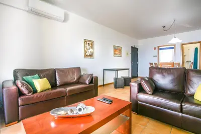 a living room with two leather couches and a coffee table at Hadassa Sunrise Refuge in Porto Santo