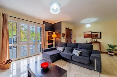 a living room with a couch and a table at Refúgio das Fontes in Senhora do Rosário