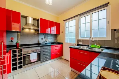 a red kitchen with red cabinets and a sink at Refúgio das Fontes in Senhora do Rosário