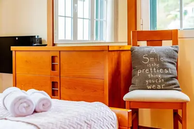 a bedroom with a dresser and a bed with towels at Refúgio das Fontes in Senhora do Rosário