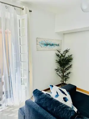 a living room with a blue couch and a window at Carreira Solar by Olá Madeira in Funchal