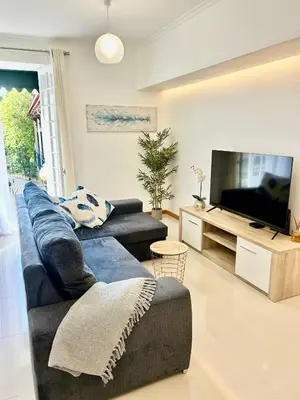 a living room with a blue couch and a television at Carreira Solar by Olá Madeira in Funchal