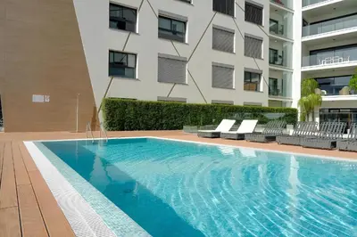 a swimming pool in front of a building at São Lucas apartamento com piscina e parking no Funchal in Funchal