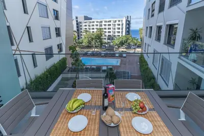 a table on a balcony with food on it at São Lucas apartamento com piscina e parking no Funchal in Funchal