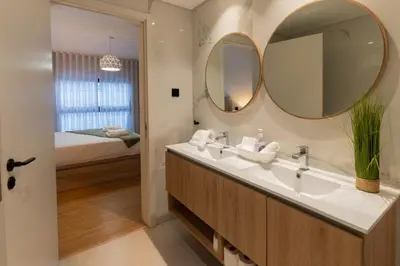 a bathroom with a sink and two mirrors at São Lucas apartamento com piscina e parking no Funchal in Funchal