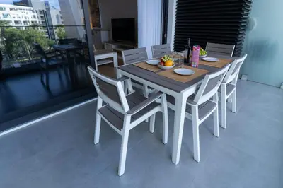 a wooden table and chairs on a balcony at São Lucas apartamento com piscina e parking no Funchal in Funchal