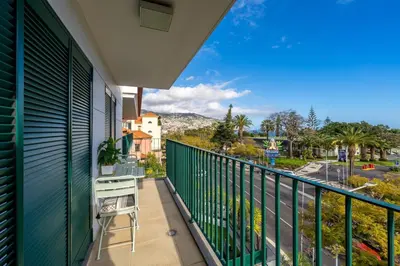 a balcony with a table and a view of a street at Manny Quinta Vitória, by Pausa Holiday Rentals in Funchal
