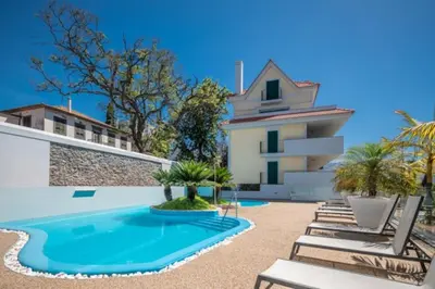 a swimming pool in front of a house at Manny Quinta Vitória, by Pausa Holiday Rentals in Funchal