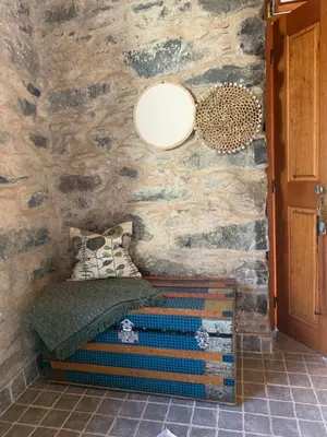 a bed in a room with a stone wall at Pico Paraiso Madeira in Ponta do Sol